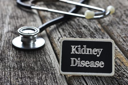 Medical Concept- Kidney Disease word written on blackboard with Stethoscope on wood background